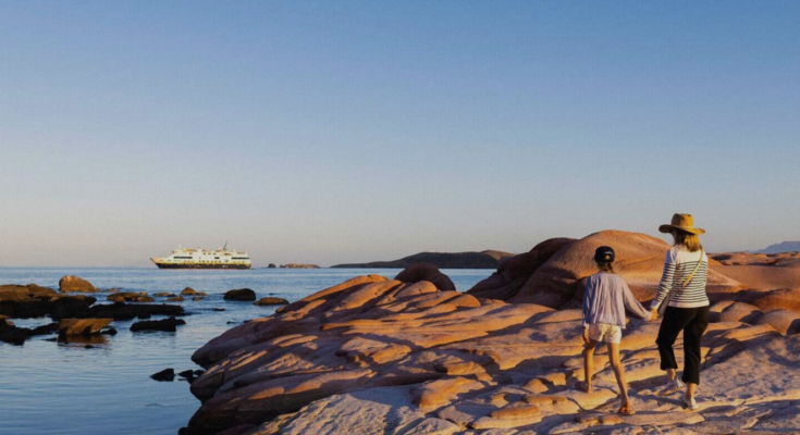 A woman with a child seeing a cruise in the sea.