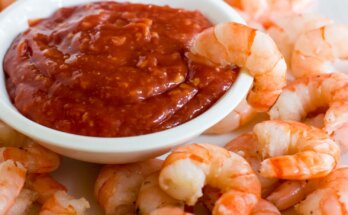 Prawns, a seafood with bowl filled with red hot and spicy sauce